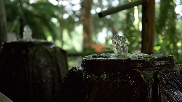 慢镜头，水缸喷泉在绿色花园视频素材