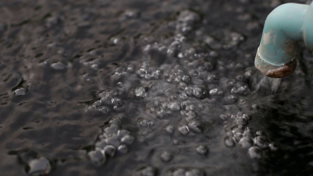 波浪和泡沫在一个罐子从打开的水龙头。视频素材