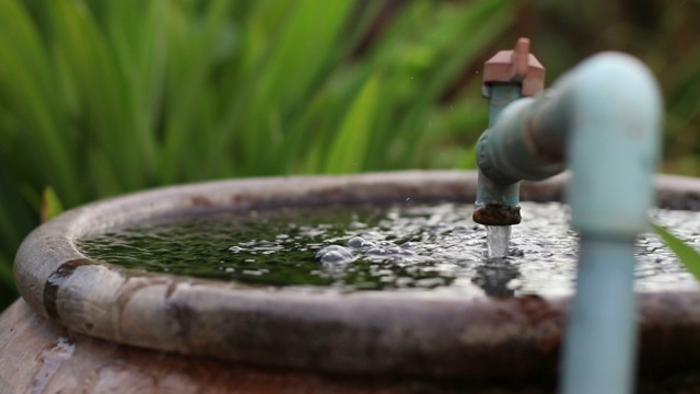 水从水龙头流入塑料瓶。视频素材