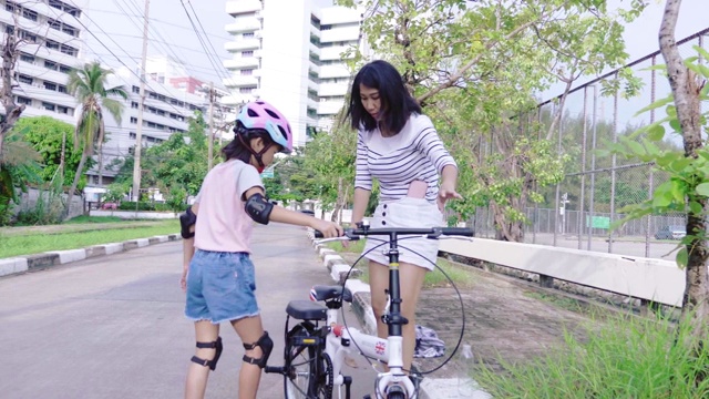 母亲教小女儿骑自行车。视频素材