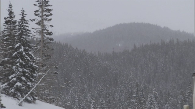 在雪山公路上，汽车超过了一辆商业卡车。视频素材