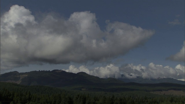 浮云飘过一座山和一个山谷。视频素材