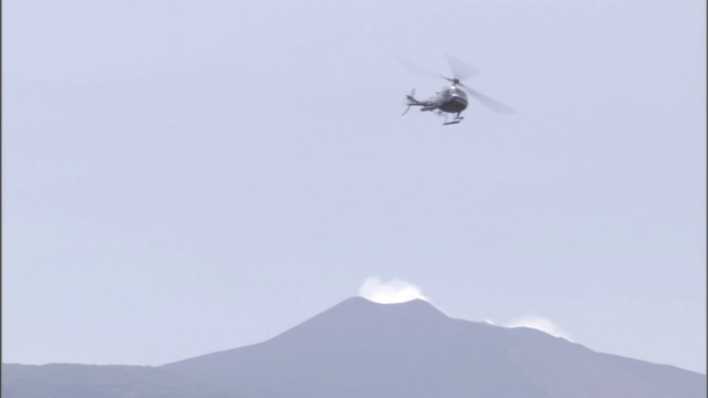 一架直升飞机载着游客在火山上空旅行。视频素材