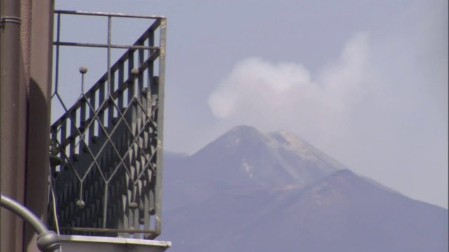 烟从远处的火山升起。视频素材