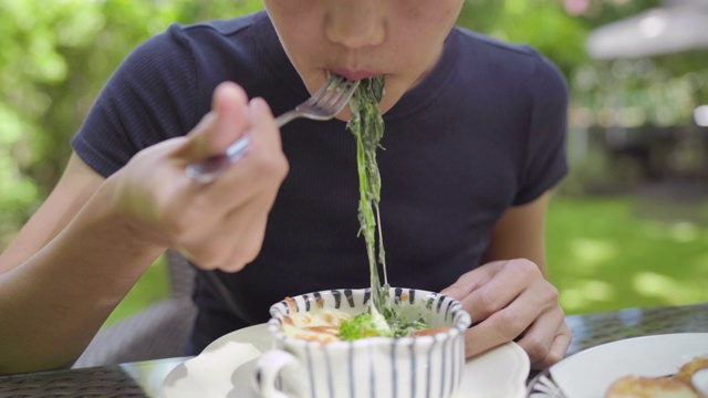 不明身份的亚洲女人吃烤菠菜和奶酪视频素材