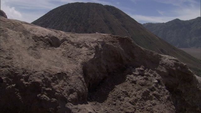 一条崎岖的山脊俯瞰着一座高大的火山。视频素材