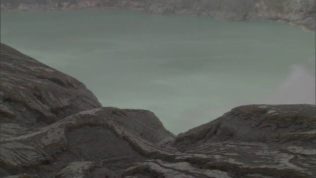 陡峭的火山峭壁构成了一个地热湖。视频素材