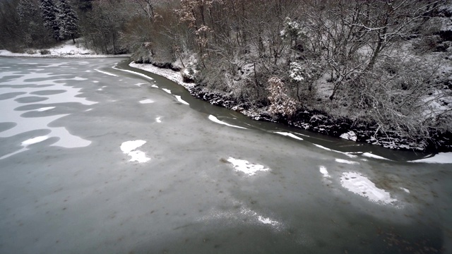 冬季的景观湖面冻结在雪中，老干树和树桩视频素材