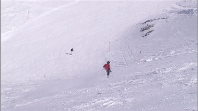 滑雪者沿着长长的斜坡滑行。视频素材