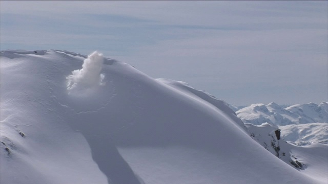 爆炸引发了雪山斜坡上的雪崩。视频素材