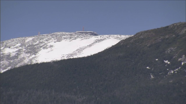 一个大型设施坐落在白雪覆盖的山顶上。视频素材