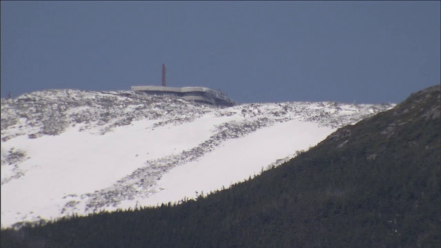 一个大型设施坐落在白雪覆盖的山顶上。视频素材