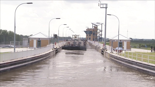 渡船沿着横跨河流的水桥行驶。视频素材