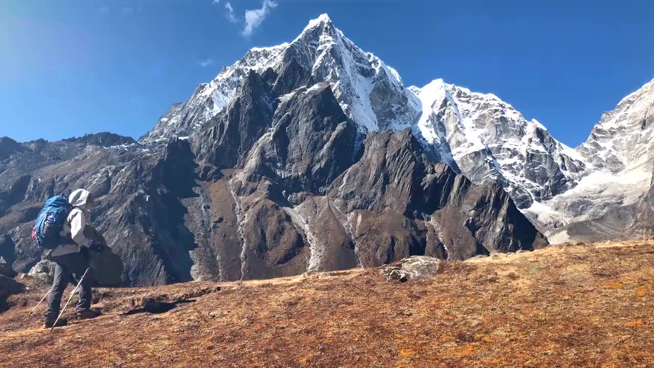 年轻的背包客女性在高海拔珠峰大本营(EBC)路线徒步旅行，背景是积雪的Tobuche 6495米山峰。极具活力的假期概念视频素材