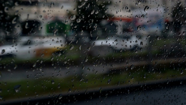 在城市的街道上开车时，汽车玻璃变成了雨滴视频素材