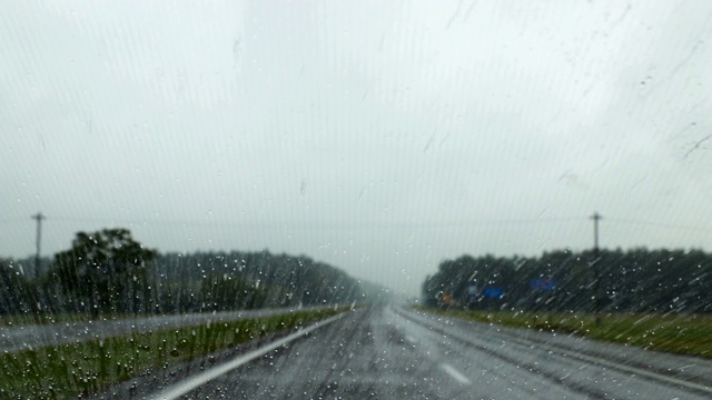 Сar是在雨天的道路上移动。雨滴滴落在有纳米涂层的挡风玻璃上视频素材