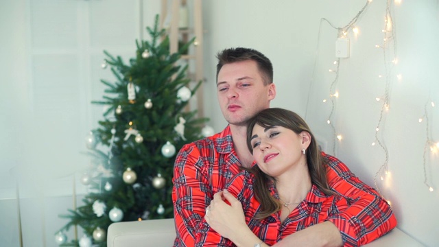 一对情侣在圣诞树旁拥抱亲吻视频素材