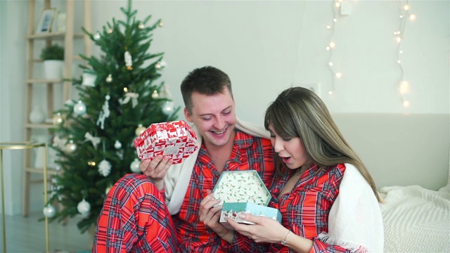 相爱的夫妇在家里交换圣诞礼物视频素材