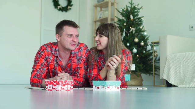 在圣诞树旁交谈和微笑的夫妇视频素材