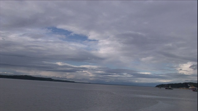 一架小型飞机在阿拉斯加海岸附近的海面上飞行。视频素材