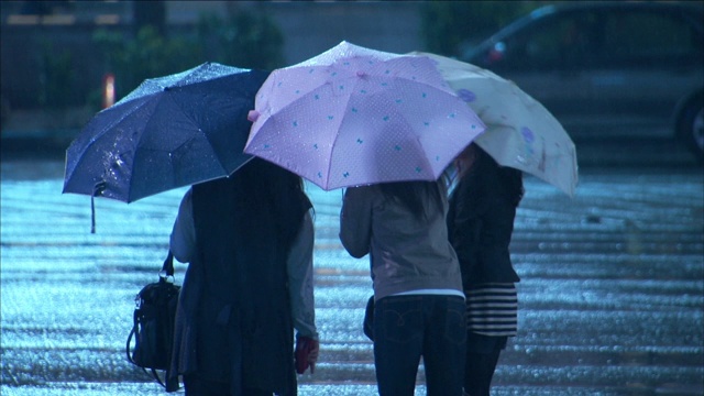 行人站在街角的雨伞下。视频素材