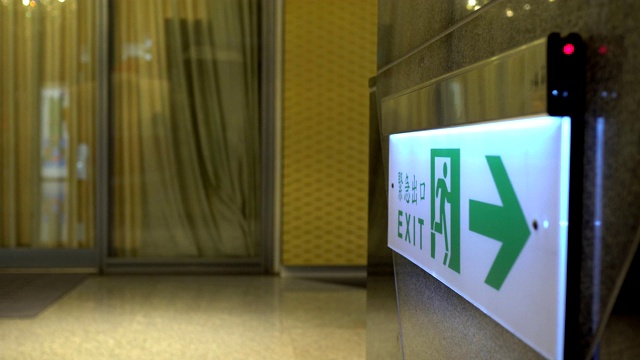 Emergency exit, escape route sign. Location in modern building in public place area. The Chinese characters "緊急出口"mean emergency exits.视频素材