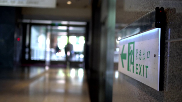 Emergency exit, escape route sign. Location in modern building in public place area. The Chinese characters "緊急出口"mean emergency exits.视频素材