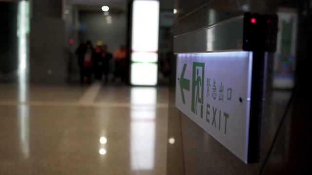 Emergency exit, escape route sign. Location in modern building in public place area. The Chinese characters "緊急出口"mean emergency exits.视频素材