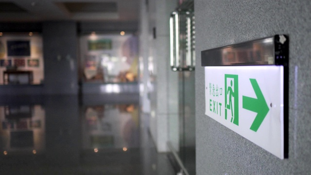 Emergency exit, escape route sign. Location in modern building in public place area. The Chinese characters "緊急出口"mean emergency exits.视频素材