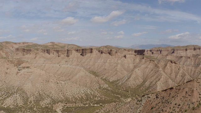 无人机在西班牙格拉纳达内华达山脉的蓝天中拍摄的Gorafe, Desierto de los colorado的干燥山谷和山脉。在安达卢西亚，有植被的西班牙沙漠峡谷。上行4 k。视频素材