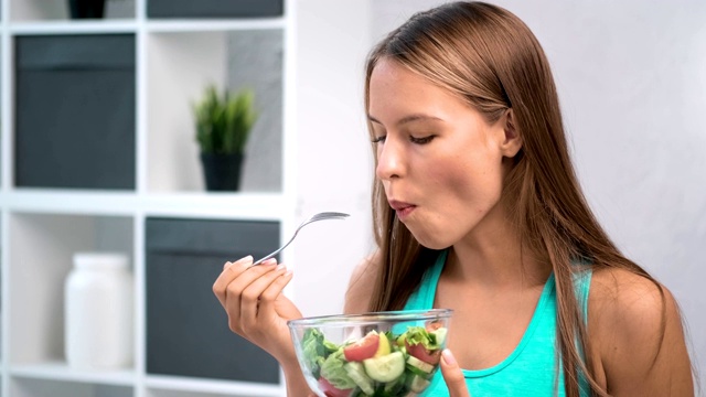 饥饿的健身女孩吃新鲜蔬菜沙拉有积极的情绪中近距离视频素材