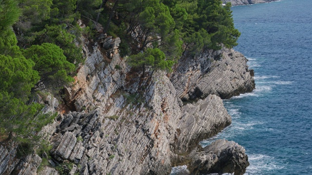 岩石和蓝色波浪海面，俯视图。自然背景视频素材