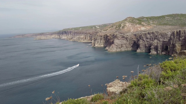 一艘白色快艇驶进海湾，展现了令人叹为观止的荒野全景视频素材