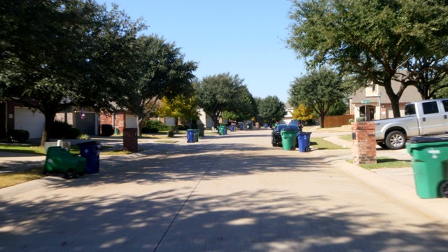 正面视图驾驶通过住宅住宅在郊区房地产街与垃圾和垃圾回收箱路边视频素材