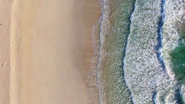 西班牙加那利群岛富埃特文图拉的Corralejo自然公园(Parque Natural de Corralejo)，空中4k全景鸟眼无人机从海滩上鸟瞰日出。大浪和日光浴床。视频素材