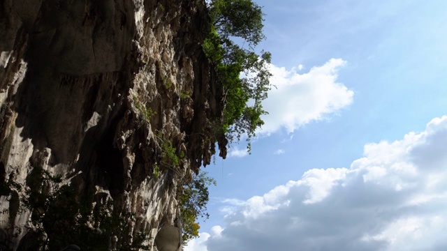 4K，拔都石窟山的岩壁与阳光和树景。高的悬崖视频素材