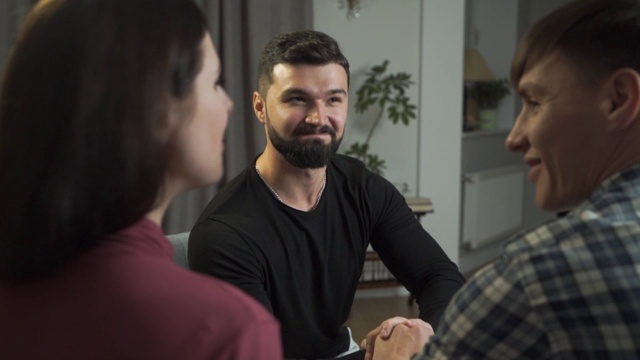 蓄着黑头发的白人男子的肖像摇动着他的病人的手。英俊的男性心理学家和他满意的客户后，成功的夫妇治疗。专业的精神分析学家。视频素材