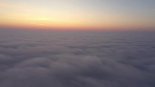 鸟瞰图。在雾中飞翔，在雾中飞翔。航空摄影机镜头。飞越云层，向着太阳。多雾的天气，从上面看。鸟的观点视频素材