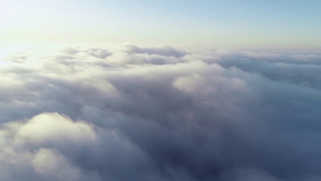 鸟瞰图。在雾中飞翔，在雾中飞翔。航空摄影机镜头。飞越云层，向着太阳。多雾的天气，从上面看。鸟的观点视频素材