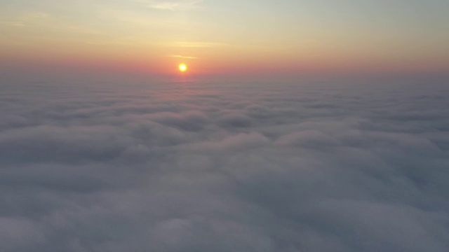 鸟瞰图。在雾中飞翔，在雾中飞翔。航空摄影机镜头。飞越云层，向着太阳。多雾的天气，从上面看。鸟的观点视频素材