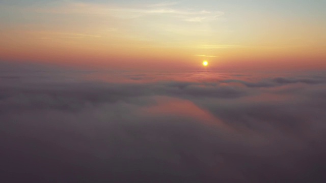 鸟瞰图。在雾中飞翔，在雾中飞翔。航空摄影机镜头。飞越云层，向着太阳。多雾的天气，从上面看。鸟的观点视频素材