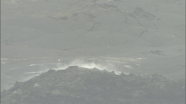 熔岩覆盖的火山周围，烟雾喷涌到空气中。视频素材