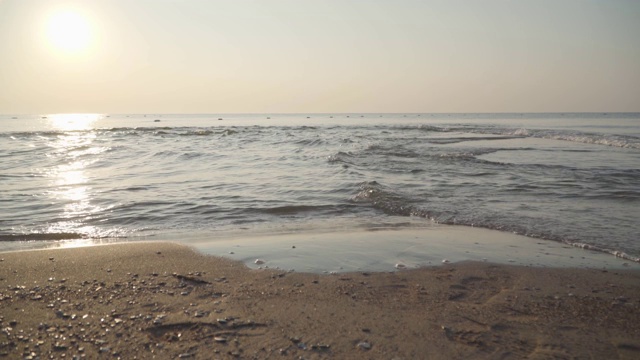 阳光下，清澈的地中海海浪翻滚到沙滩上。特写镜头平静的泡沫水。美丽的土耳其自然。视频素材