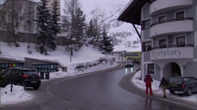 一座陡峭嶙峋的山耸立在一个滑雪胜地的上空。视频素材