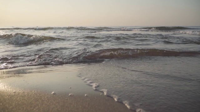 镜头靠近地中海的海浪翻滚到沙滩上。美丽的土耳其自然。特写镜头平静的泡沫水在日落或日出。视频素材