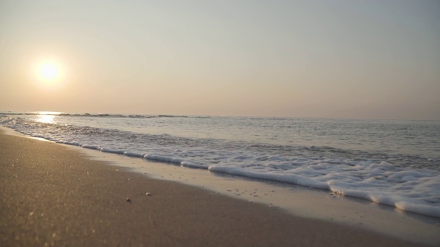 地中海的泡沫海浪在沙滩上翻滚。特写镜头的水晶清澈的水在阳光。美丽的土耳其自然。视频素材