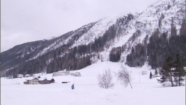 在雪崩路径的底部，有一道石头栅栏保护着建筑物。视频素材