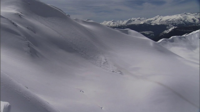 爆炸会在白雪覆盖的山坡引发雪崩。视频素材