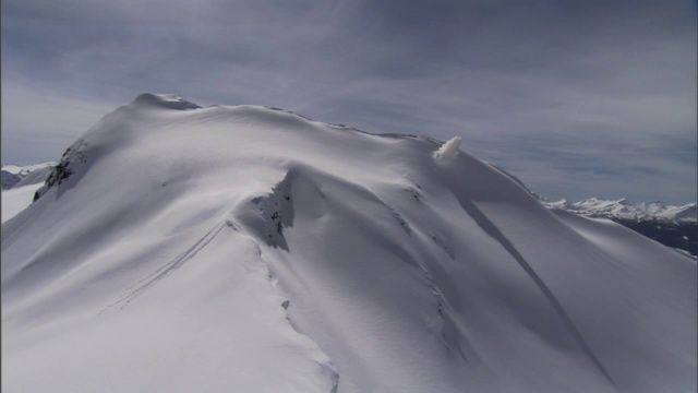 爆炸会在陡峭的山坡上引发雪崩。视频素材