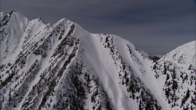 两次爆炸引发了陡峭的白雪覆盖的山峰上的雪崩。视频素材